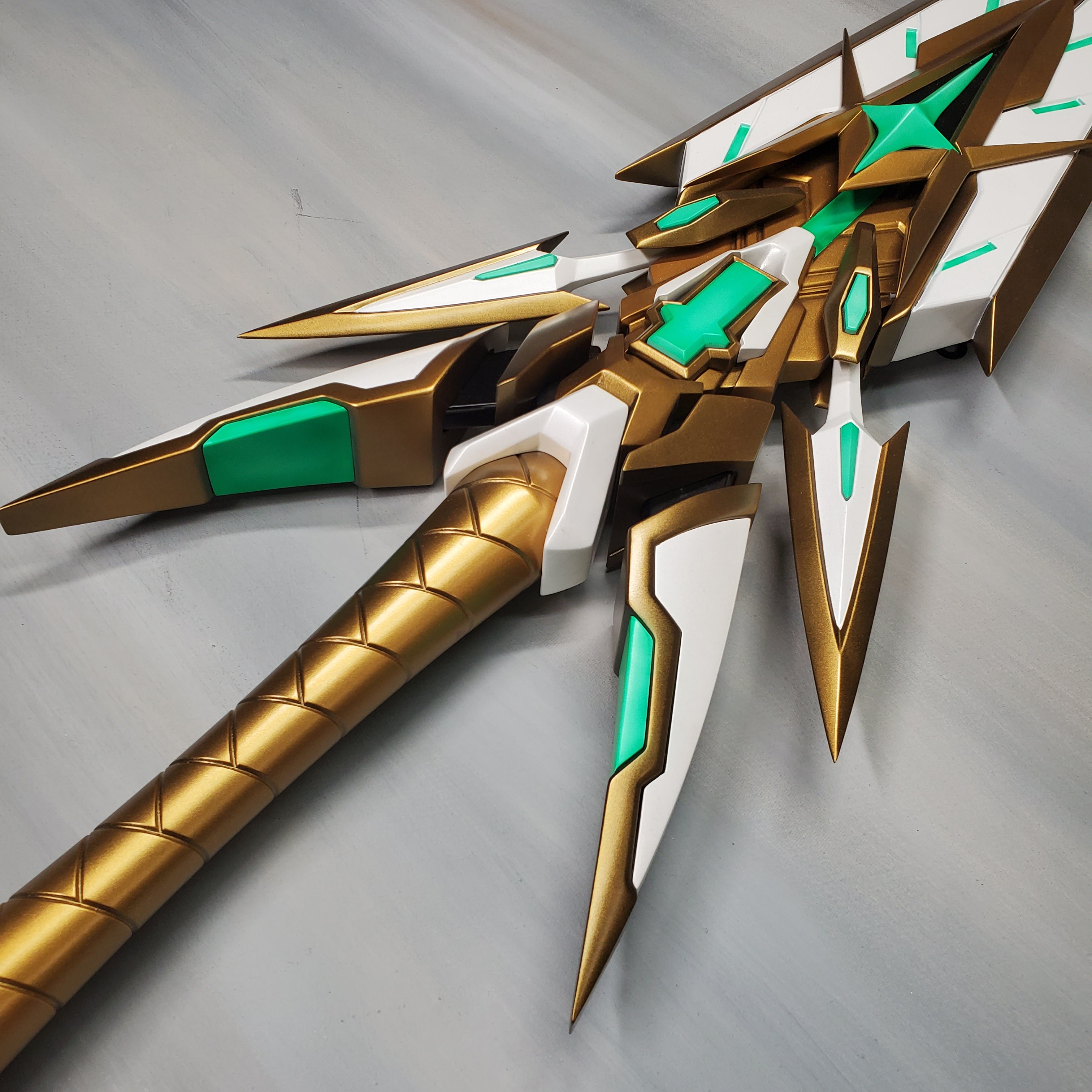 Gold and green futuristic weapon on a gray background