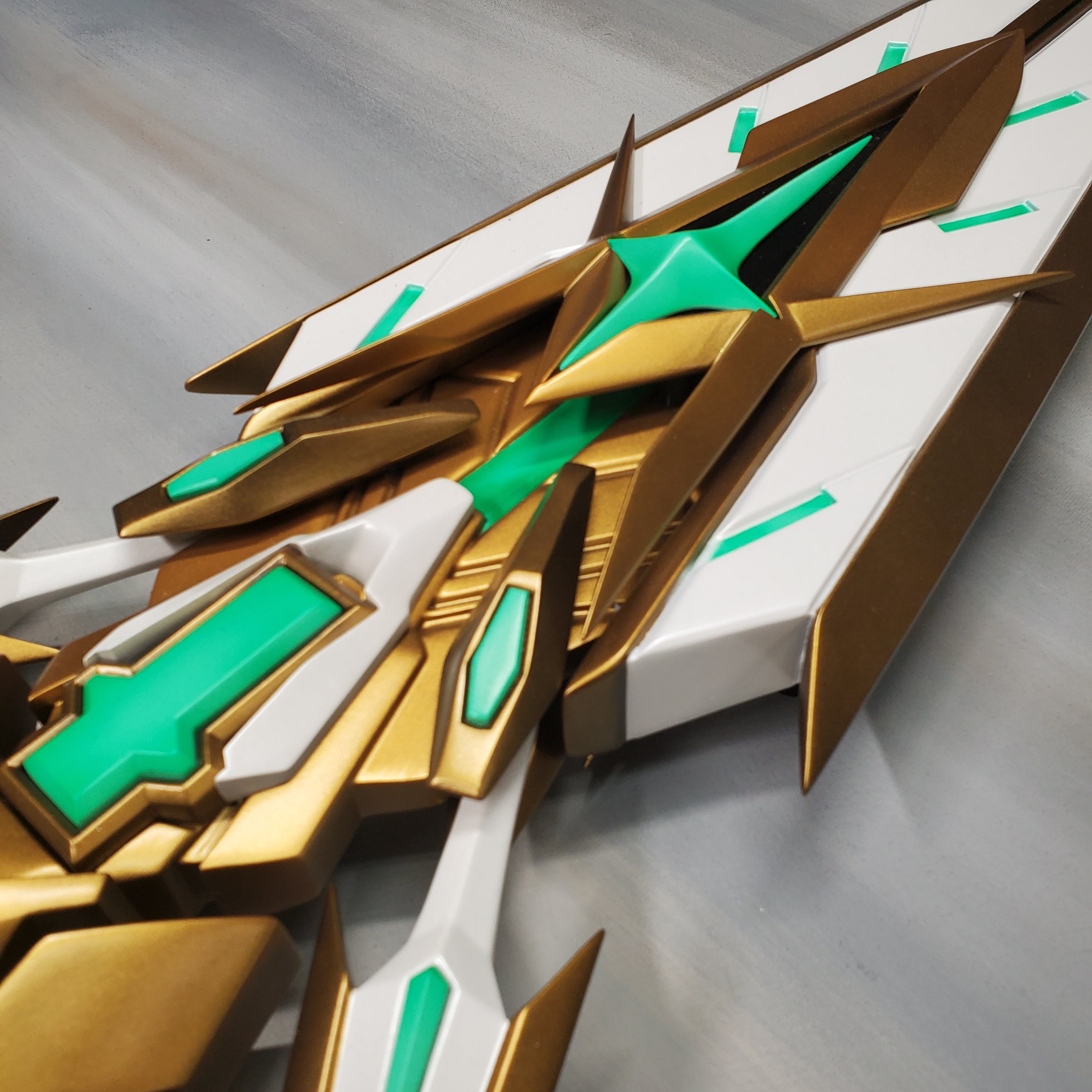 Close-up of a gold and green mechanical design on a gray background