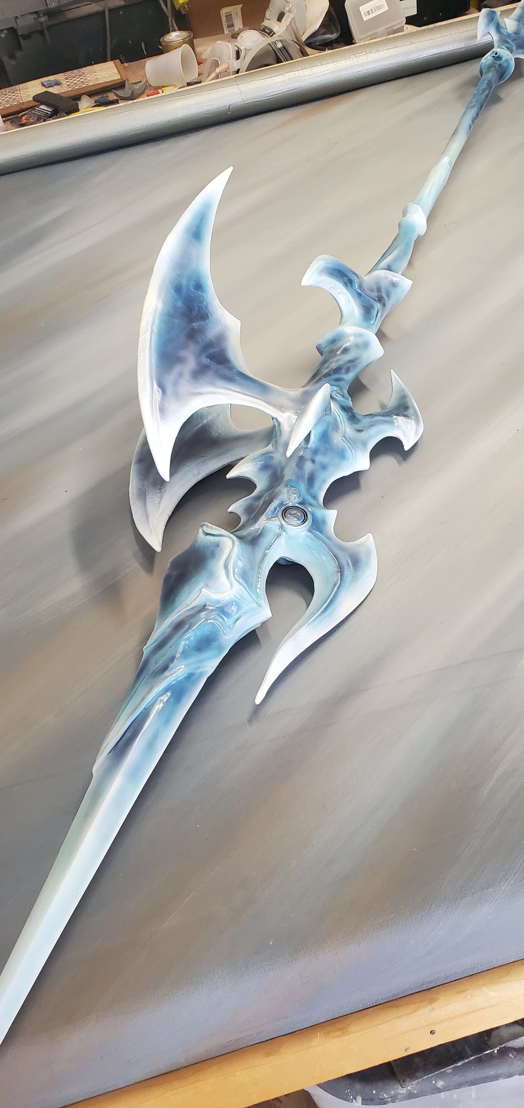 Decorative weapon with blue and silver design on a plain background