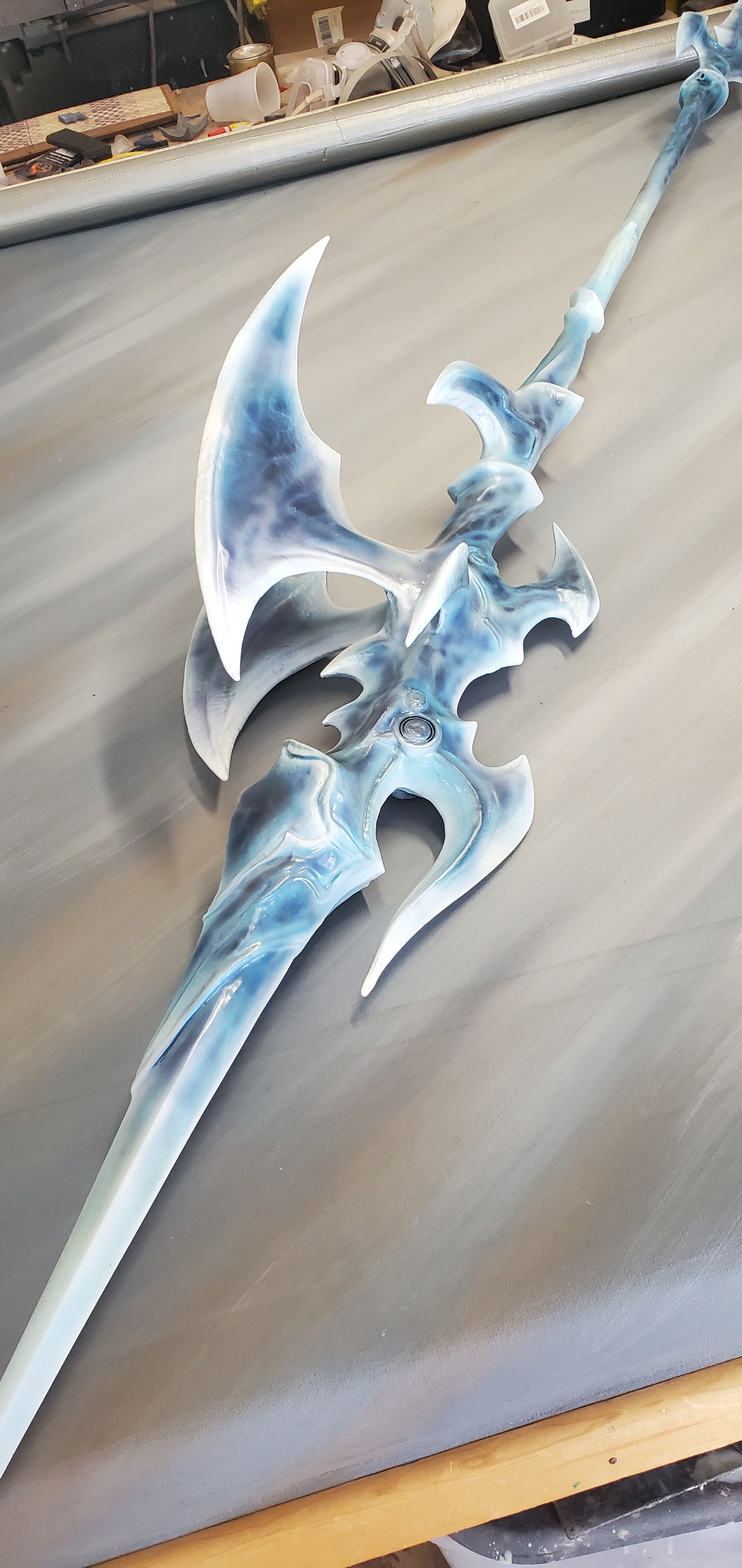 Decorative weapon with blue and silver design on a plain background