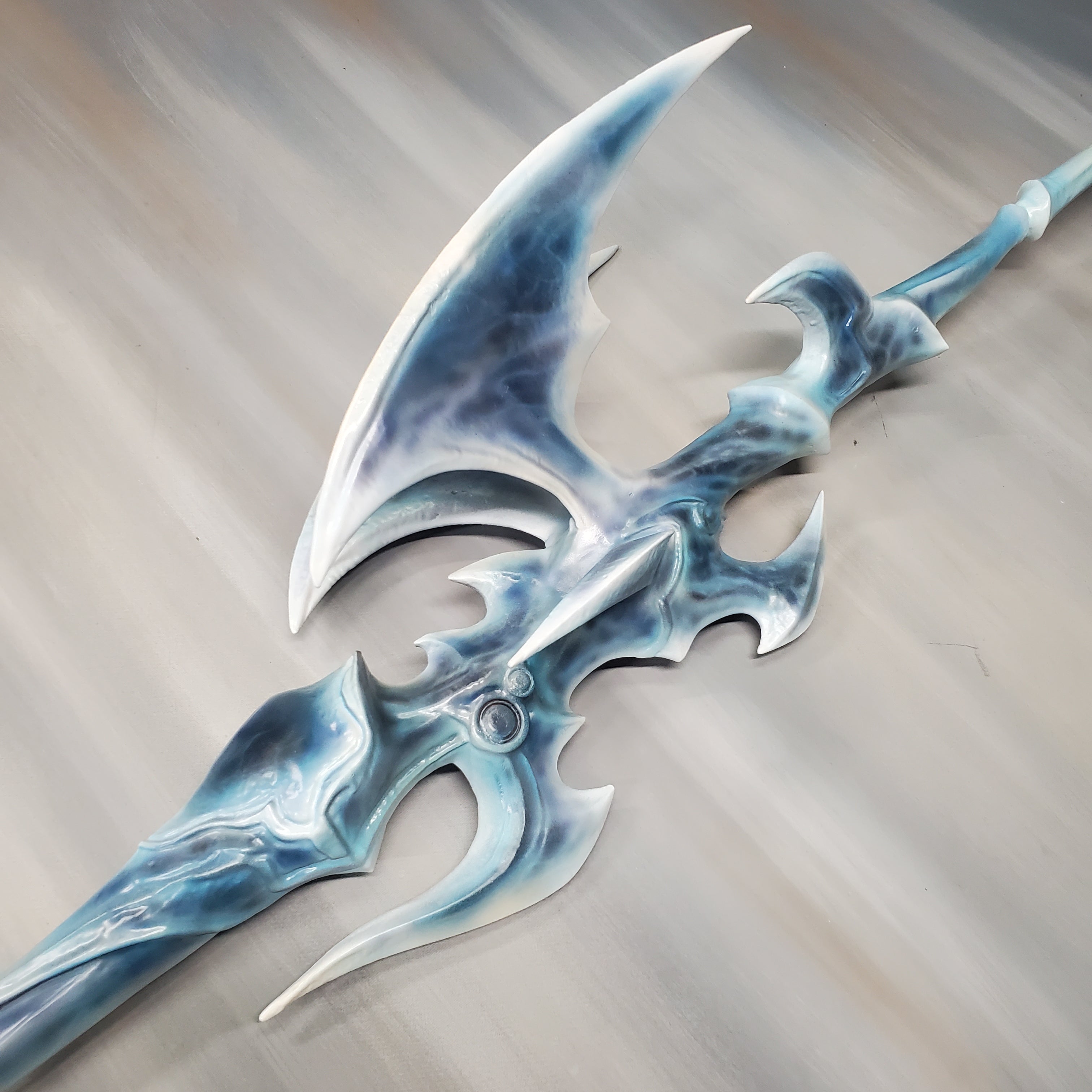 Decorative axe with blue and silver design on a neutral background