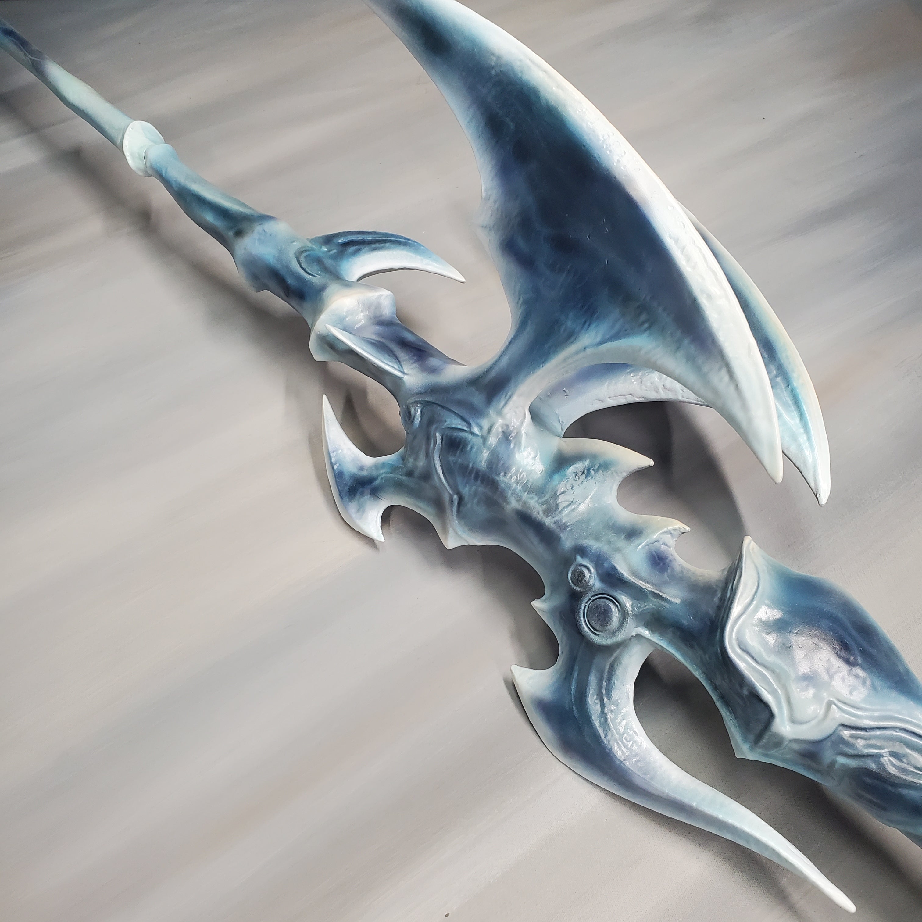 Fantasy weapon with blue and white design on a gray background