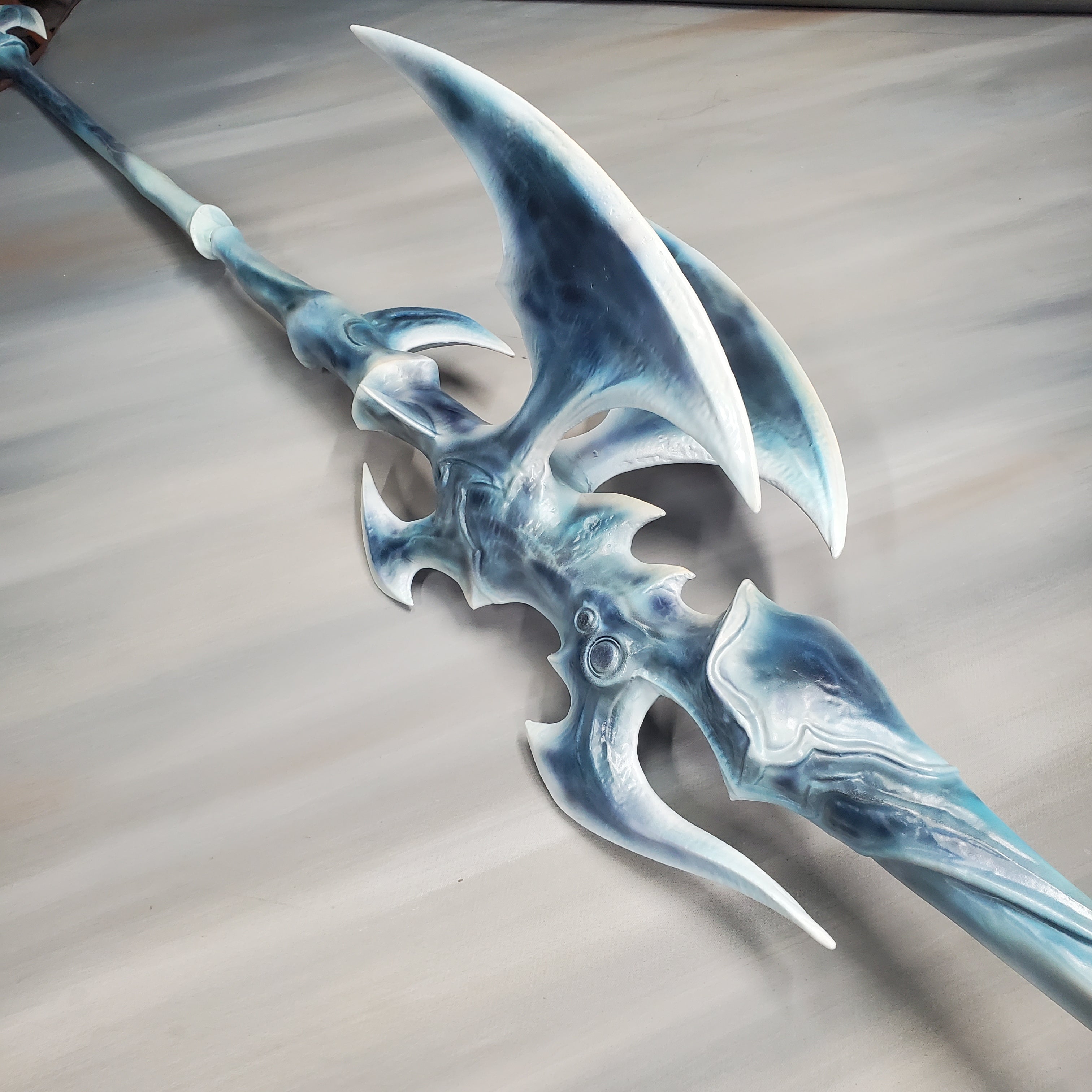 Fantasy axe with blue and white design on a gray background