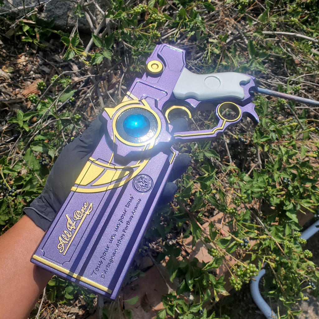 Purple and yellow toy gun with blue light held in front of green foliage