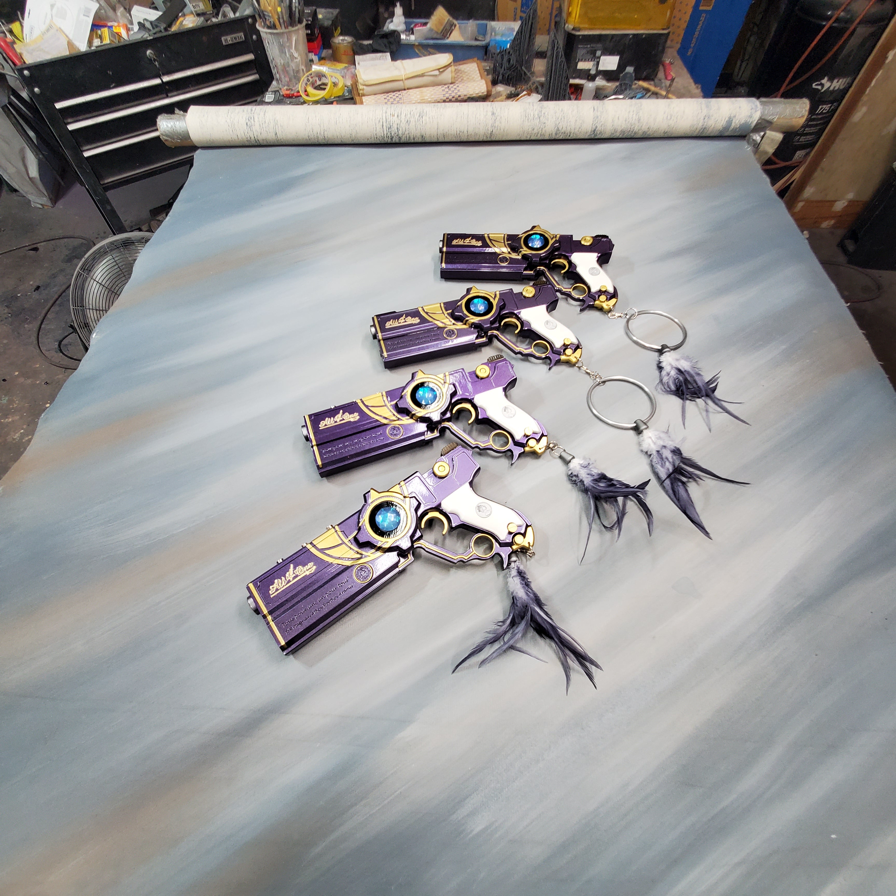 Decorative keychains with purple and gold design on a textured surface