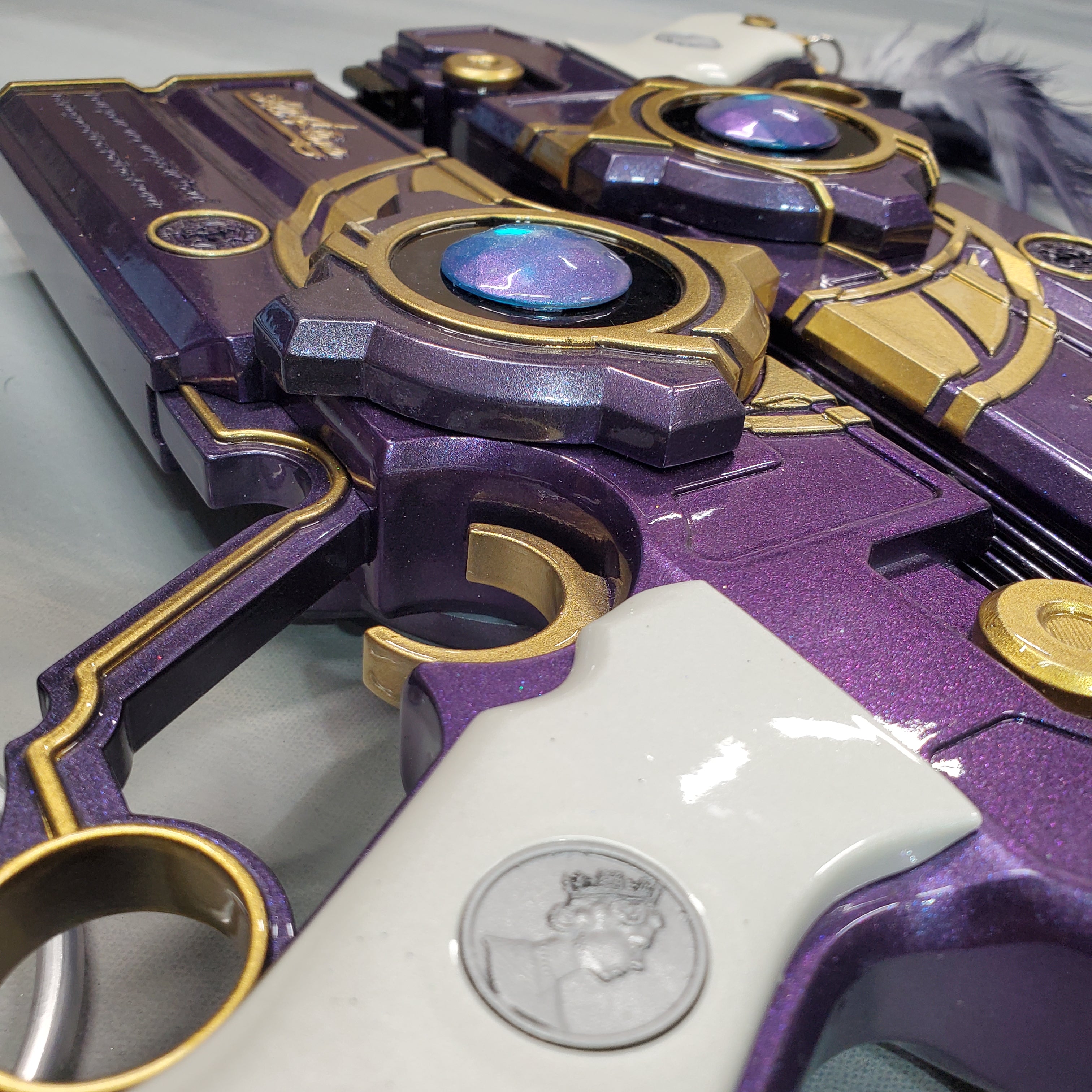 Close-up of a purple and gold toy gun with intricate design