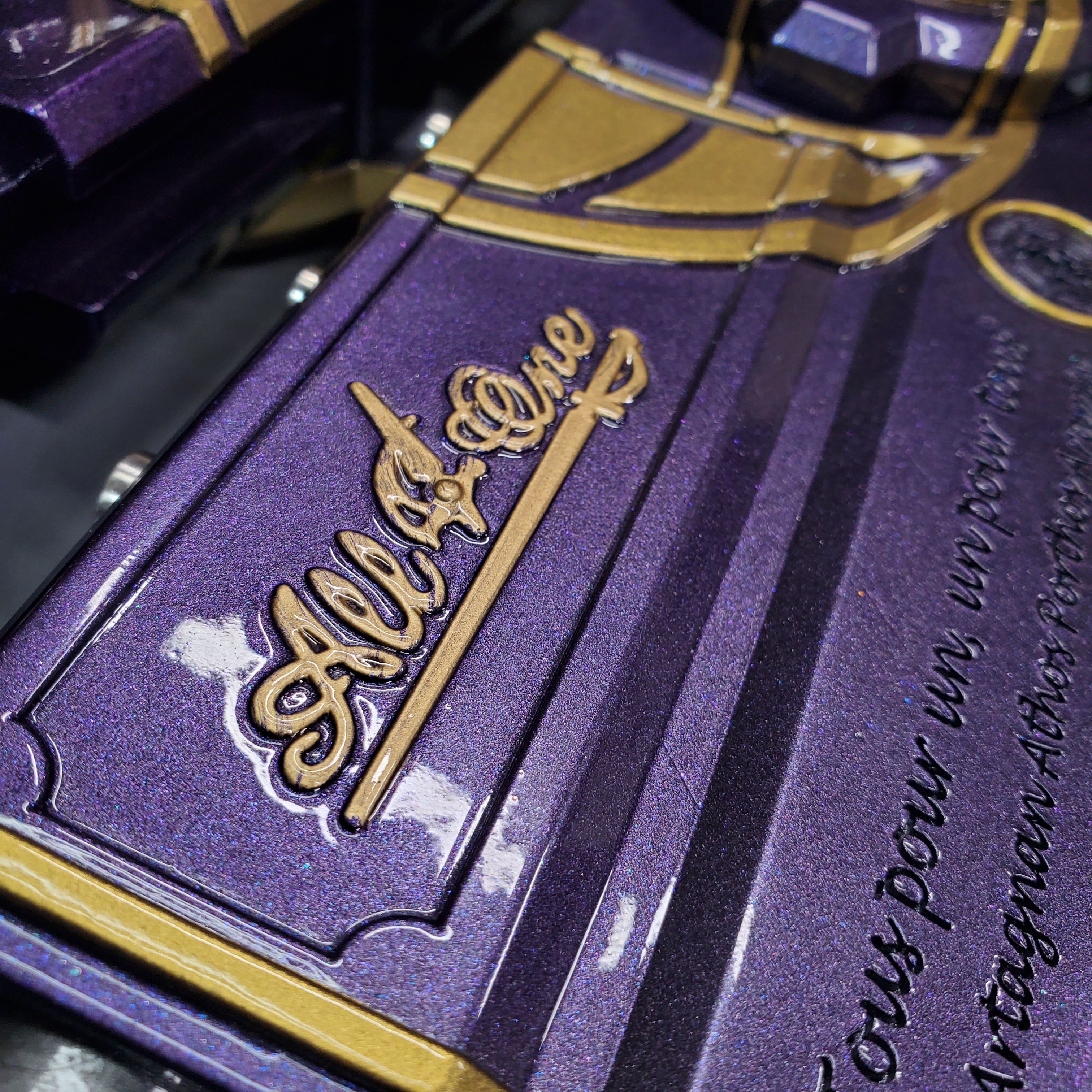 Close-up of a purple and gold product with text and design details.