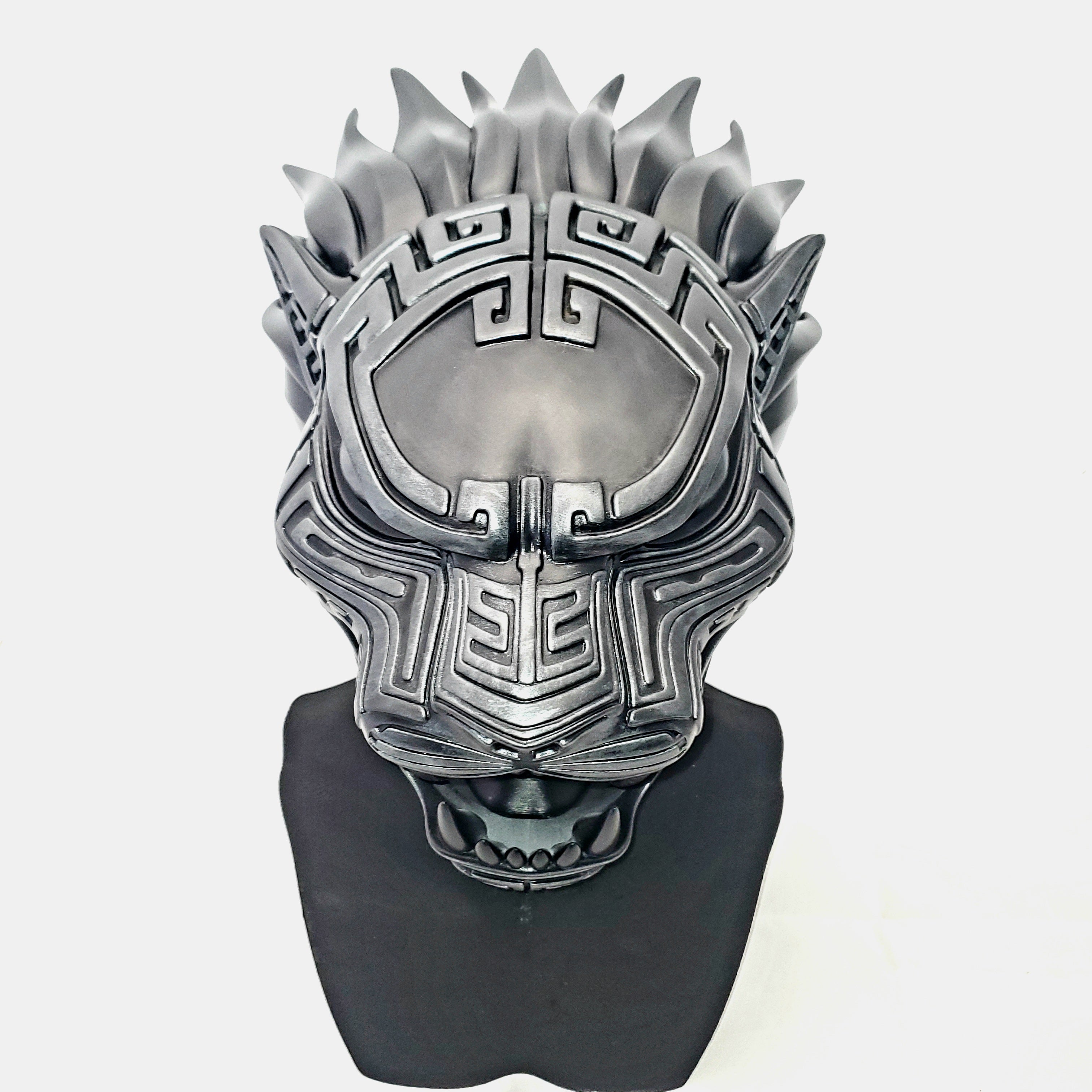 Silver mask with intricate design on a white background
