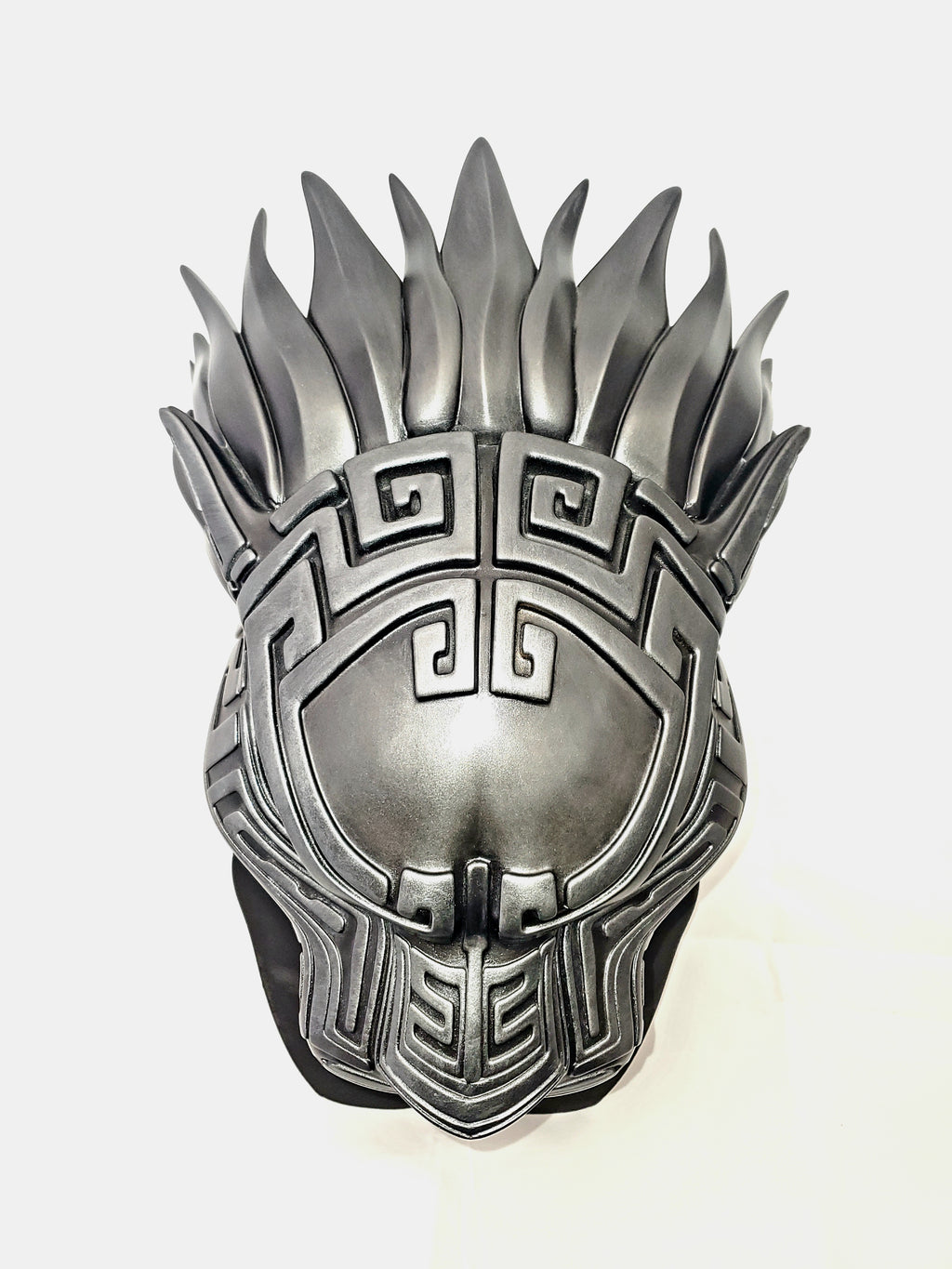 Silver mask with intricate designs on a white background