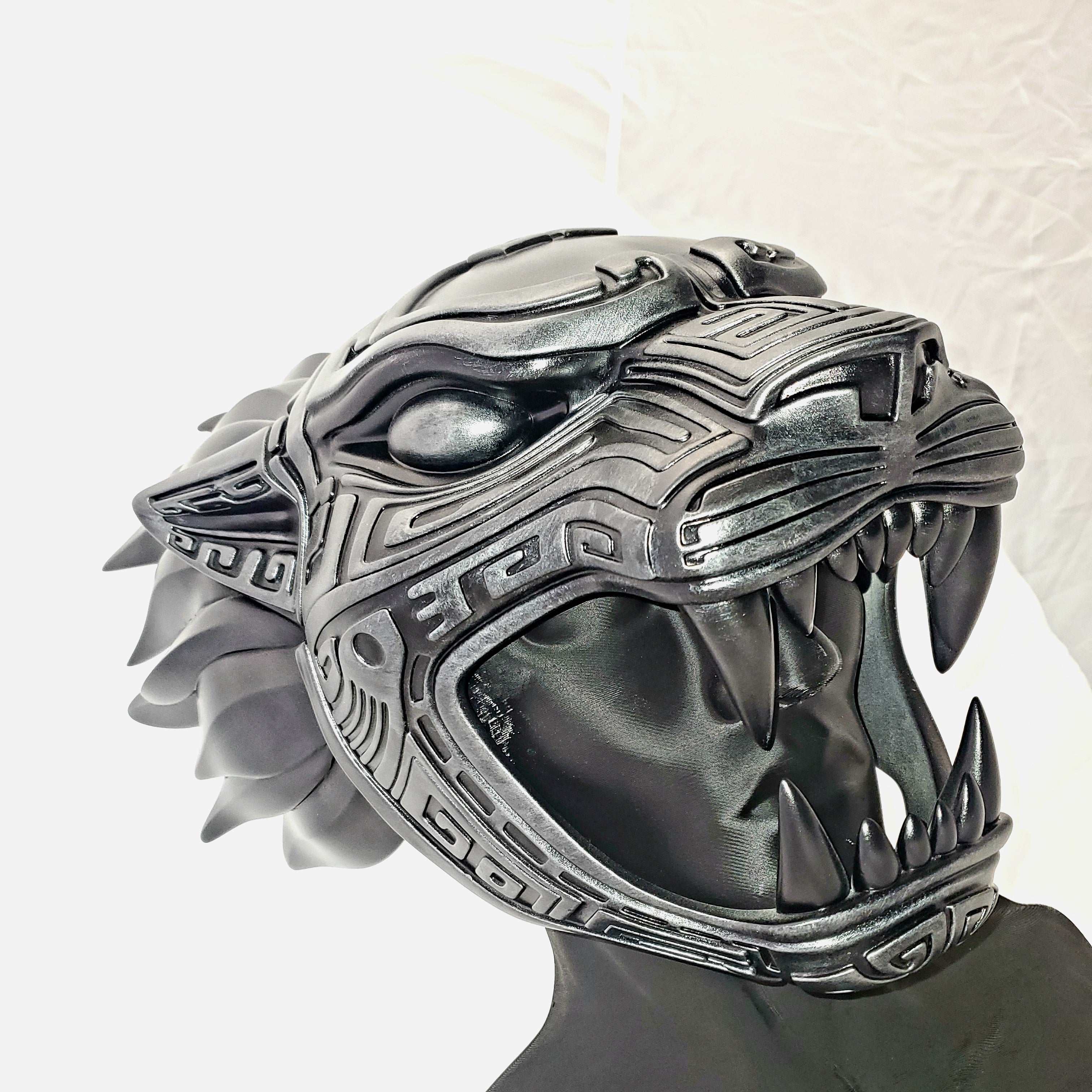 Silver panther head sculpture on a white background