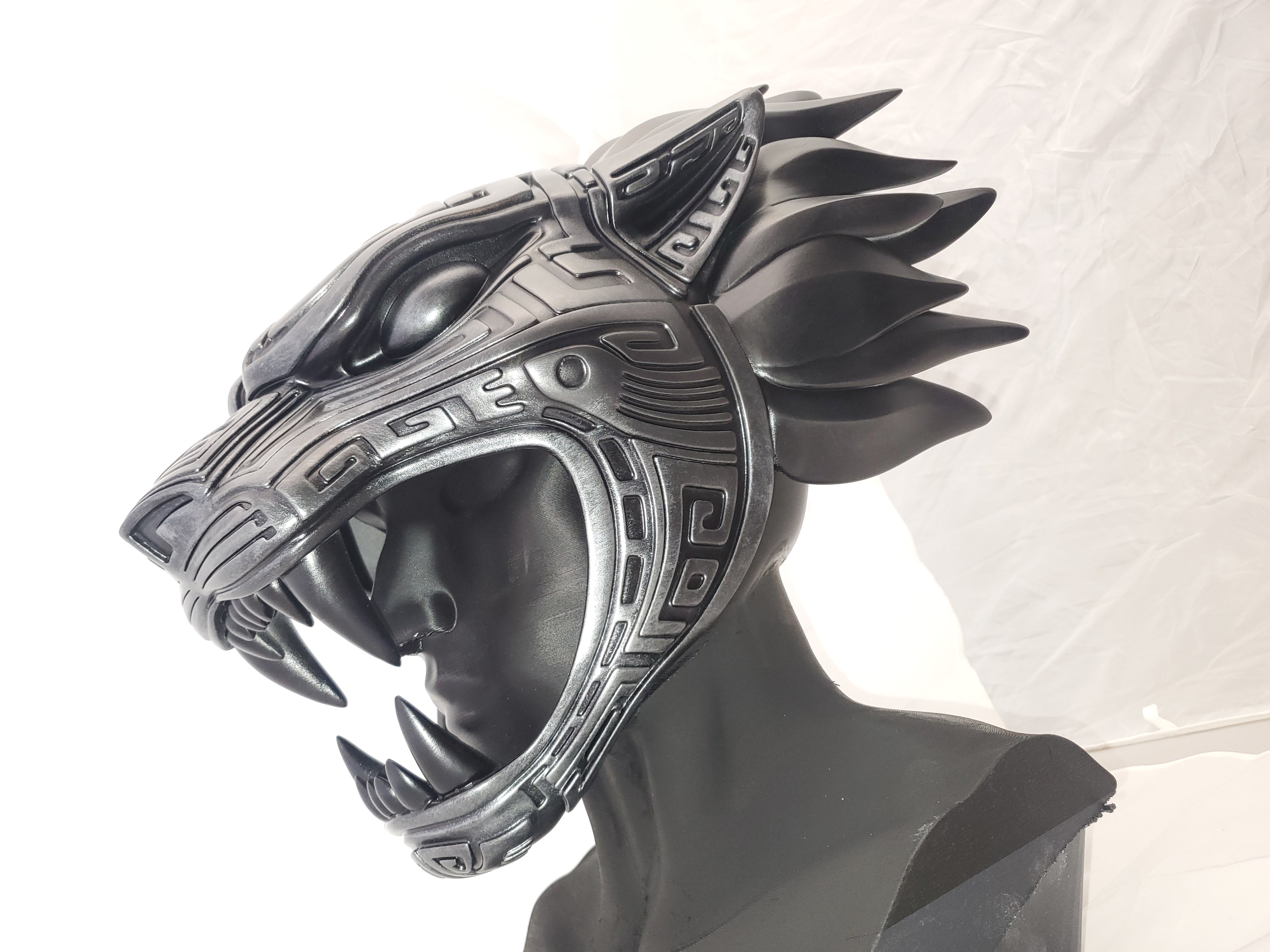 Decorative helmet with wolf design on a mannequin head against a white background