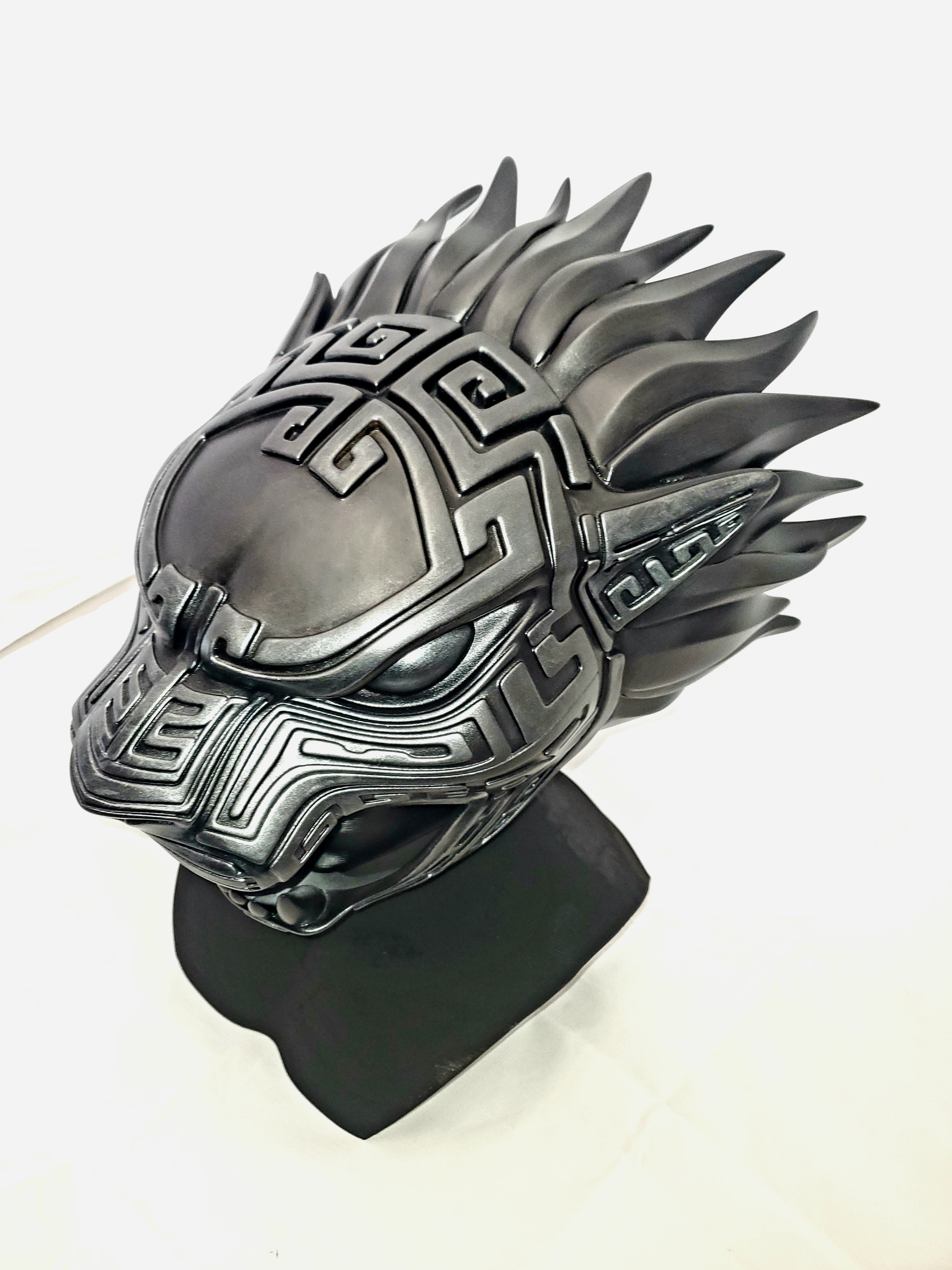 Metallic dragon helmet on a stand with a white background