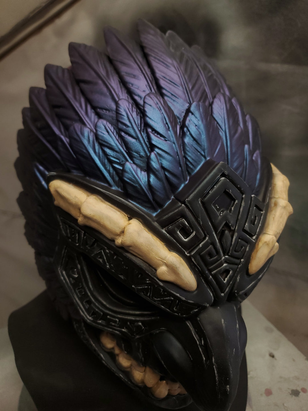Decorative object with black and blue feather-like design on a dark background