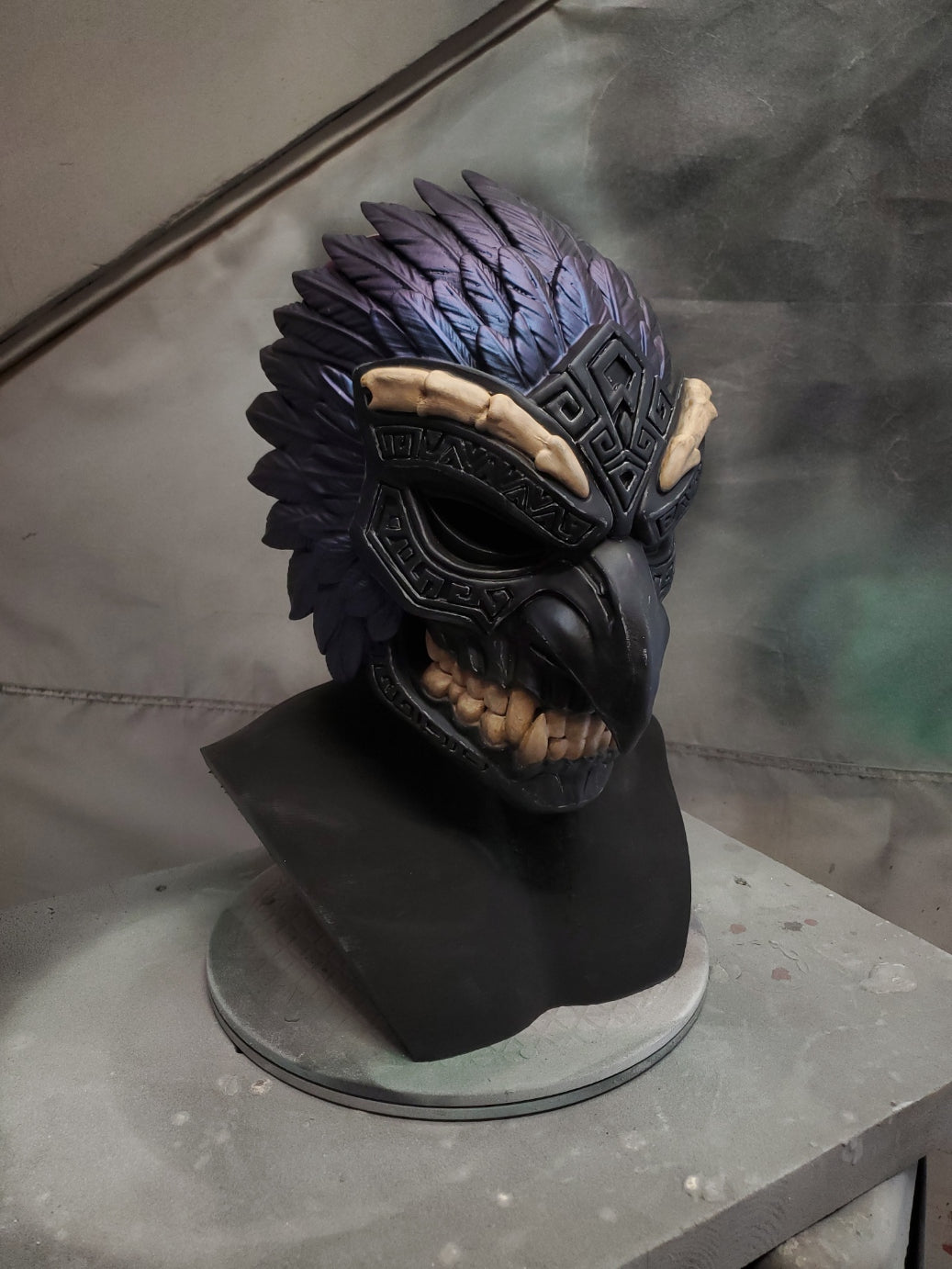 Black and purple fantasy-style helmet on a stand with a blurred background