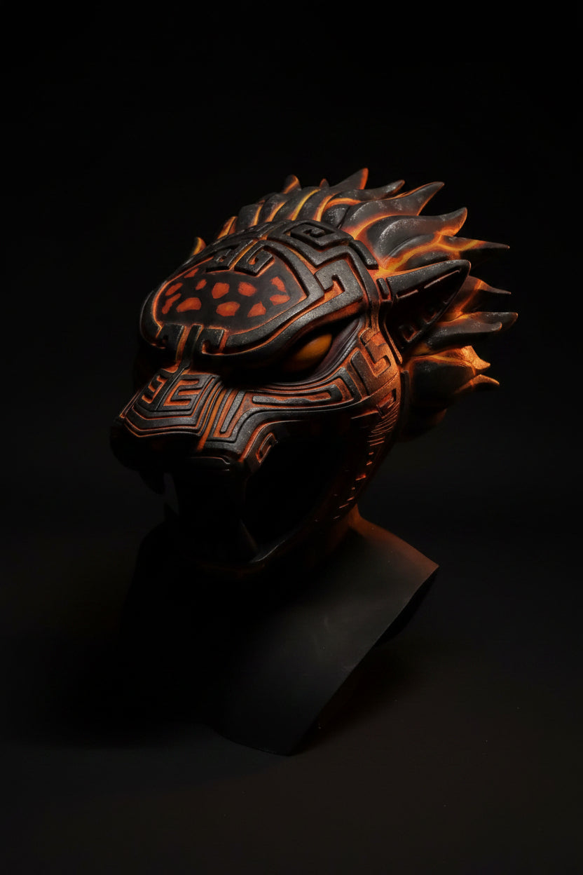 Black and orange mask with intricate designs on a gray background