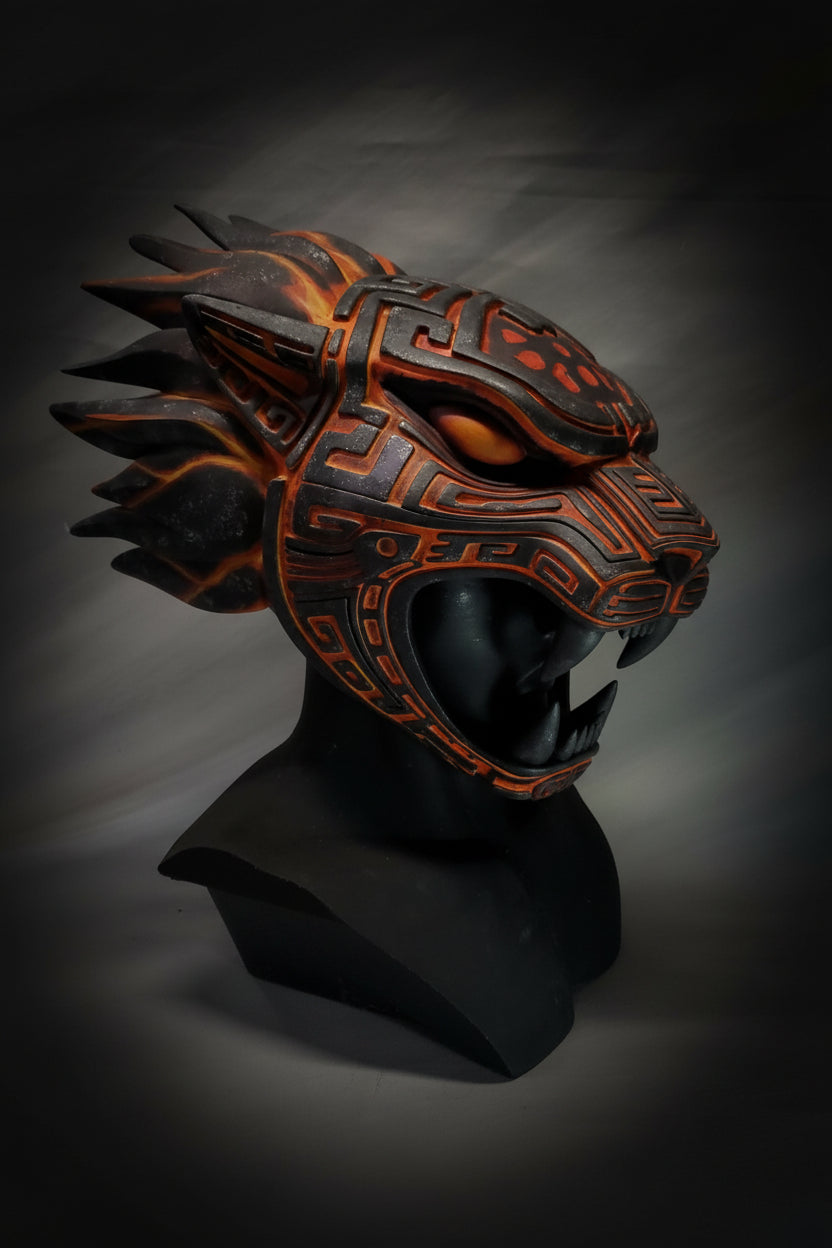 Decorative mask with tribal patterns and orange accents on a gray background