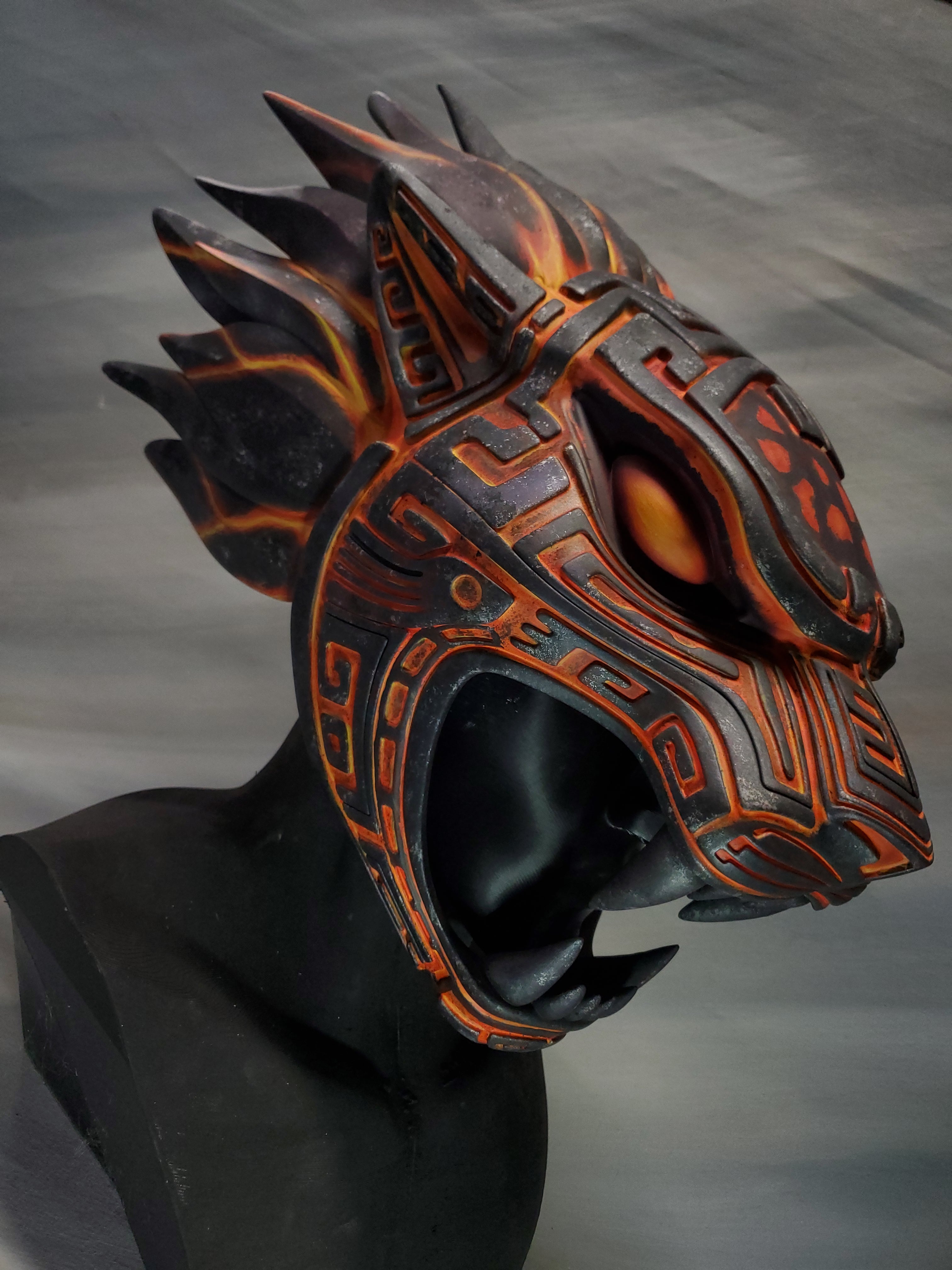 Dragon-like helmet with orange and black design on a gray background