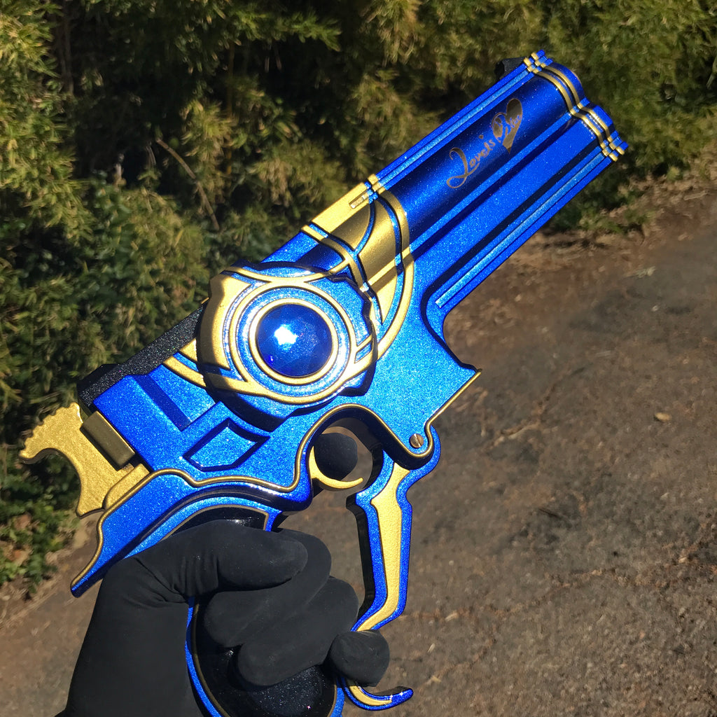 Blue and gold toy sword held by a gloved hand with a natural background