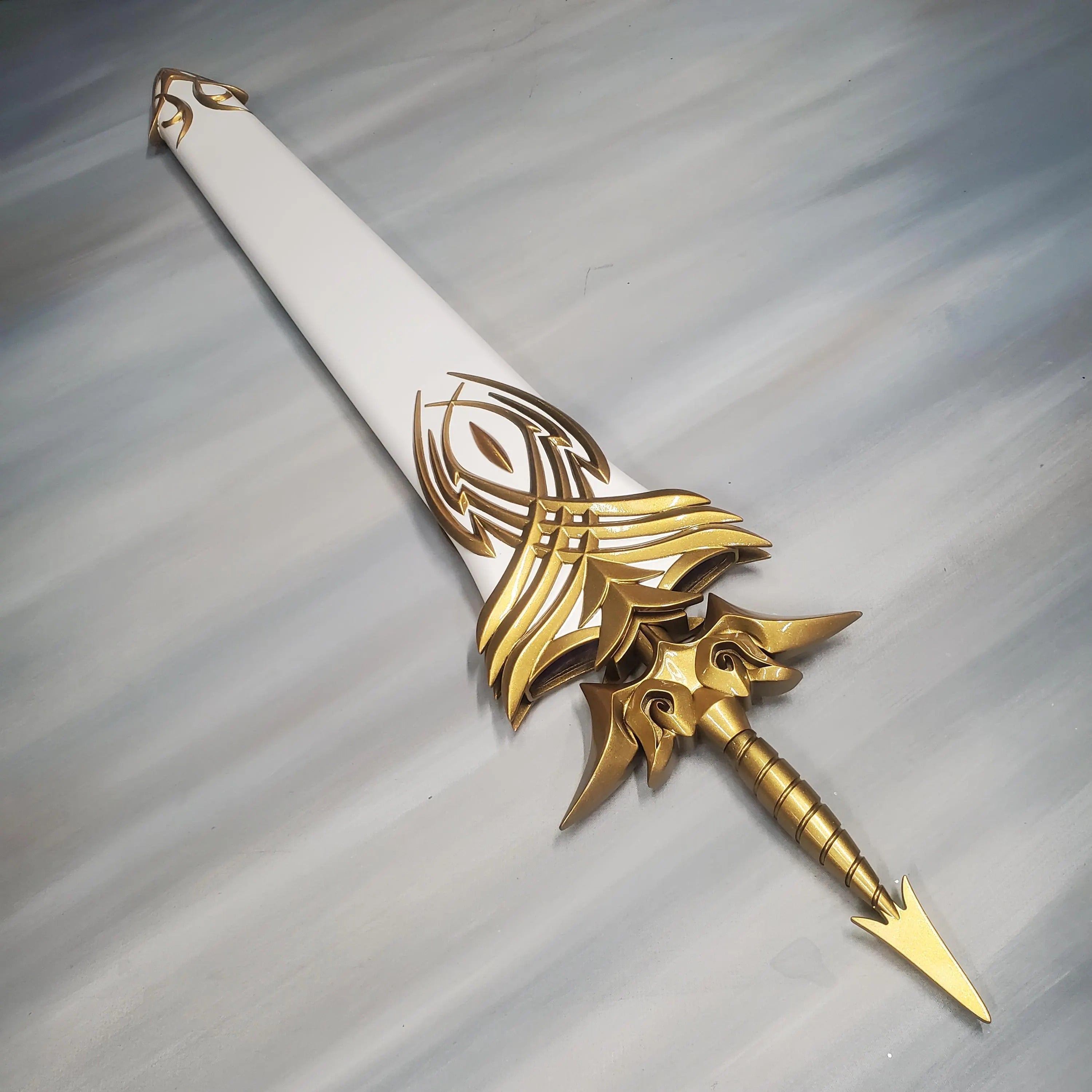 Decorative sword with gold and white design on a gray background