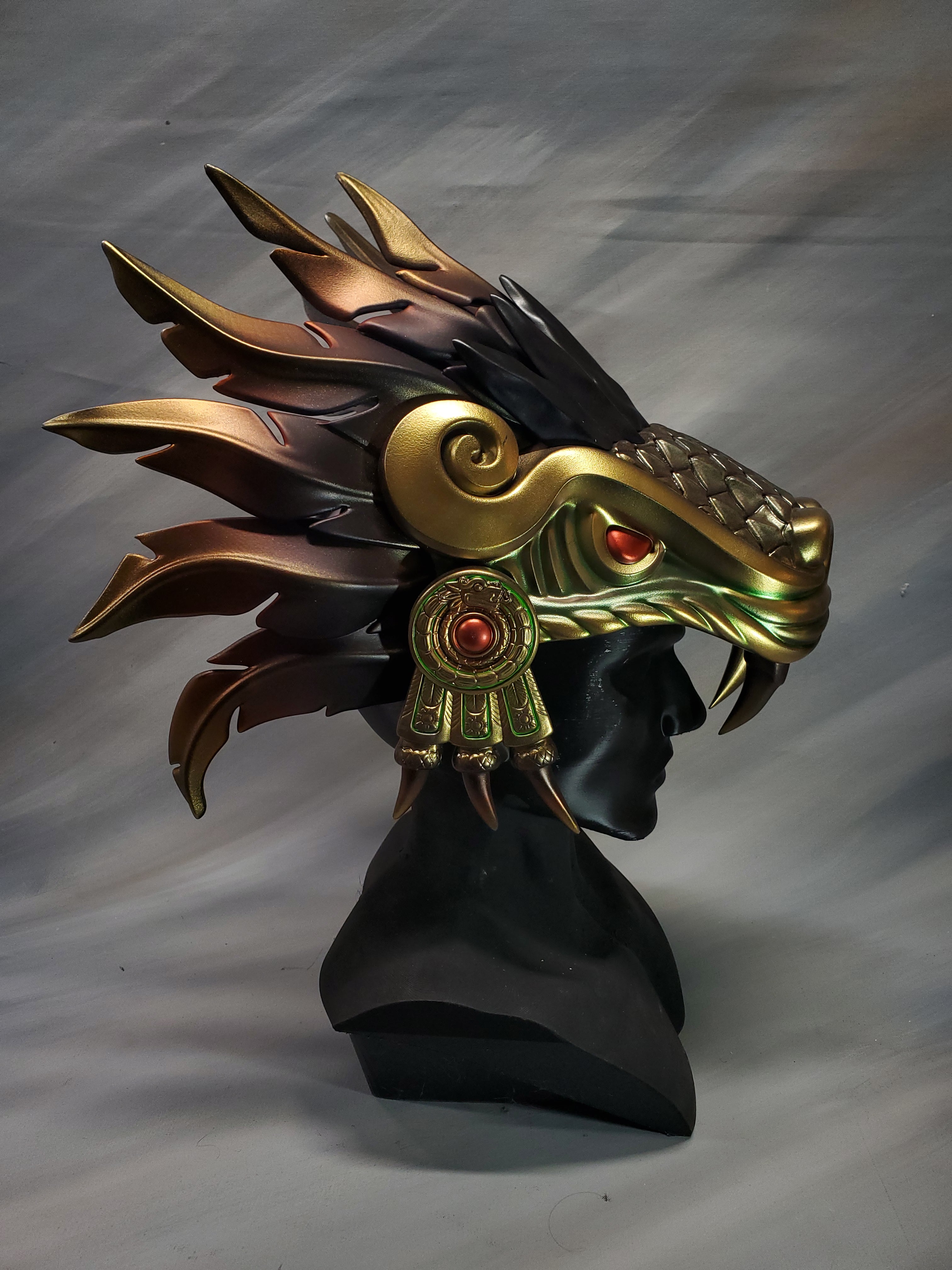 Decorative headpiece with gold and black design on a gray background